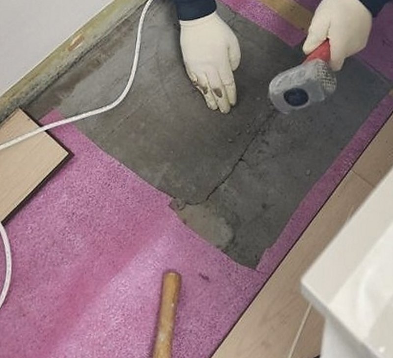 공항동 누수탐지로 표시한 자리만 마루를 걷고 콘크리트를 망치로 조금씩 깨는 모습